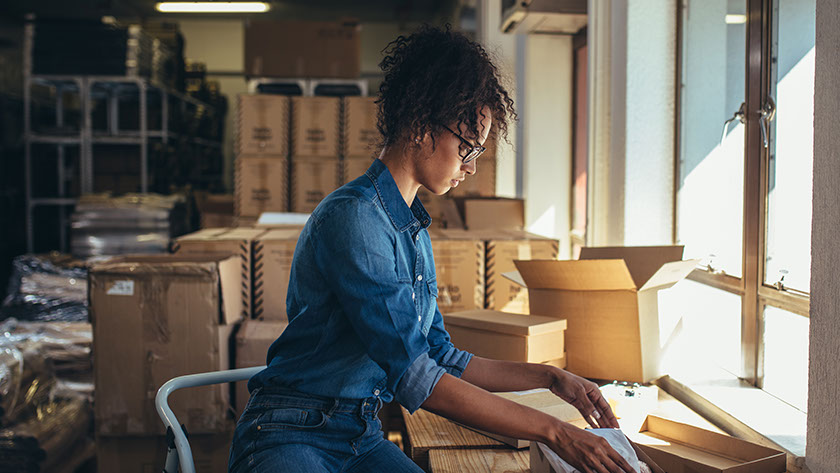 A small business owner works to package her merchandise.